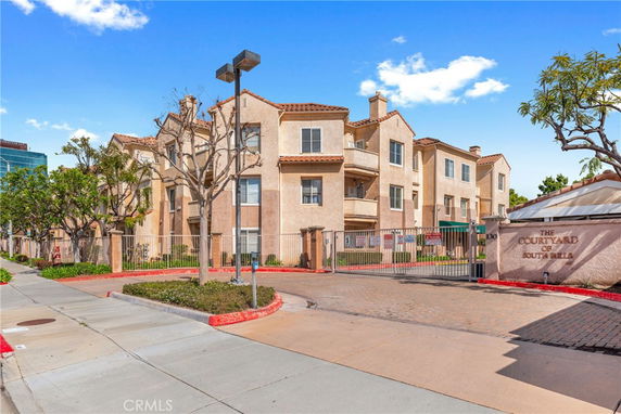 Front view of a multi-story residential building with a gated entrance.
