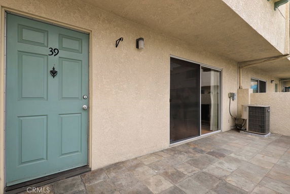 Front view of a house entrance with a teal door and sliding glass door.