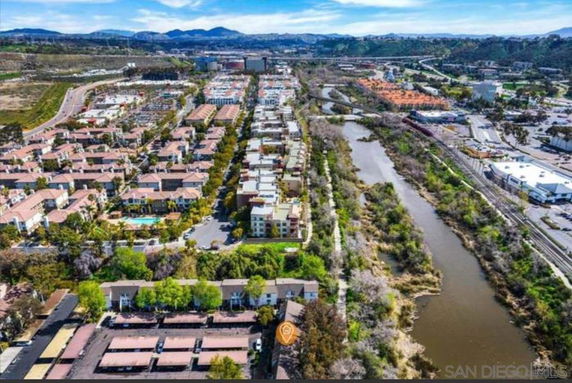 Panoramic view of residential area and river with surrounding landscape.