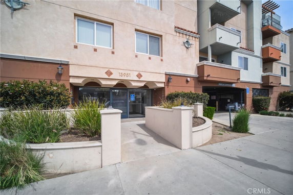 Front view of a multi-story residential building with a parking entrance.