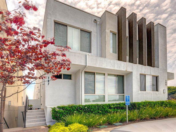 Front view of a modern two-story building with rectangular windows and vertical design elements.
