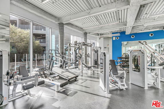 Indoor gym area with exercise equipment and large windows.
