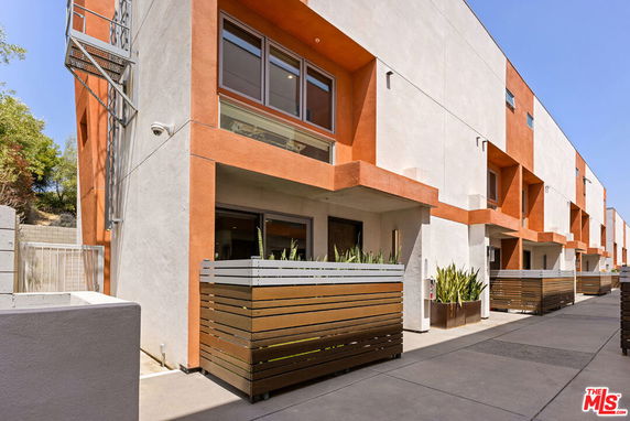 Front view of a modern multi-story building with orange and white exterior.