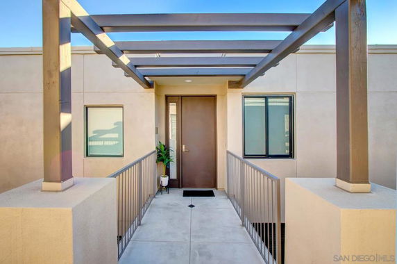 Front view of a modern house with a pergola entrance.