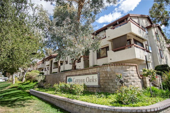 Front view of a multi-story residential building with balconies and exterior stairs.