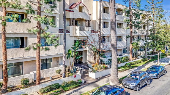 Front view of a multi-story residential building with balconies and a central entrance.
