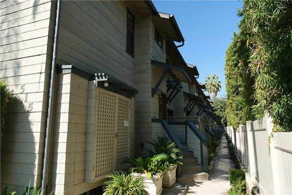 Front view of a multi-story townhouse complex with a walkway.