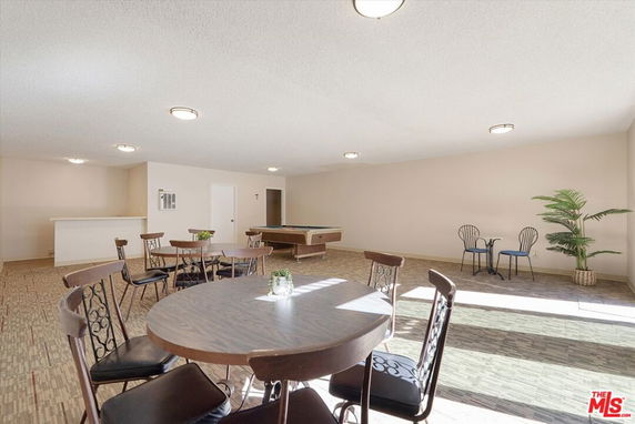 Room with tables, chairs, and a billiards table.