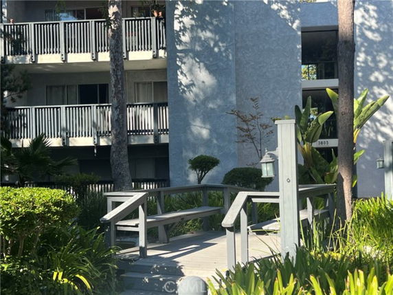 Front view of a multi-story building with balconies and a walkway.