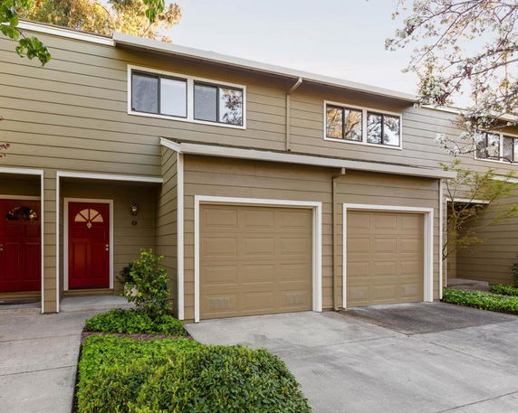 Front view of a two-story house with two garages and red front doors.