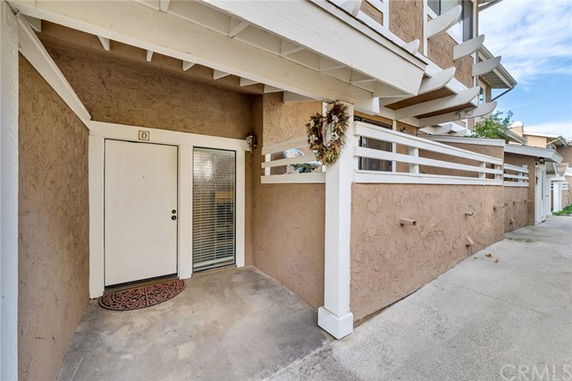 Entrance view of a building with covered entryway and decorative wreath on the door.