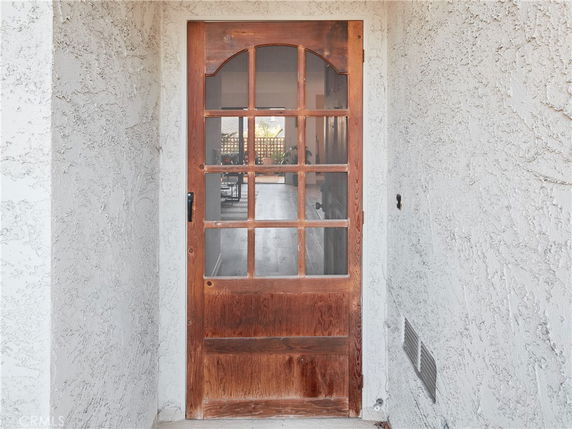 Front entrance with a wooden door featuring glass panels.