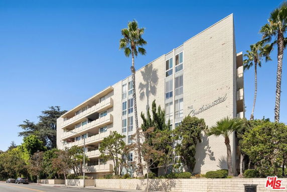 Front view of a multi-story apartment building with balconies.