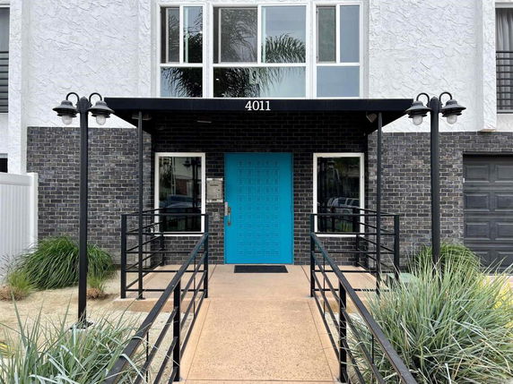 Front view of a building with a blue door and brick facade
