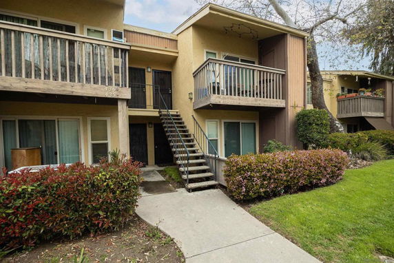Front view of a two-story apartment building with exterior staircases and balconies.