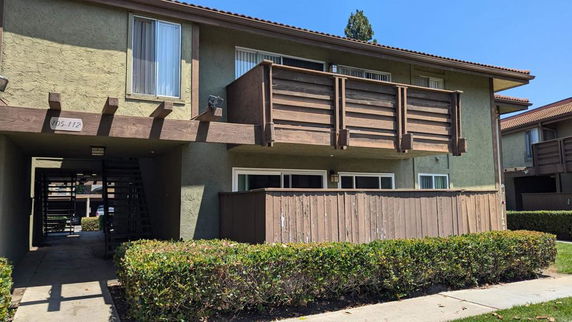 Front view of a two-story apartment building with balconies.