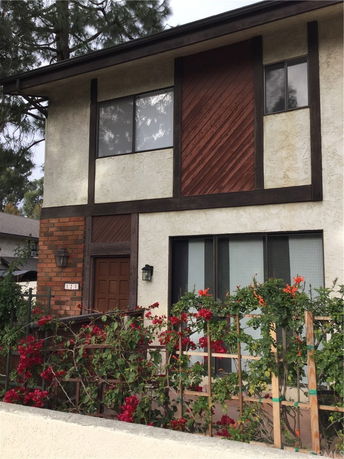 Front view of a two-story house with a wood and stucco finish.