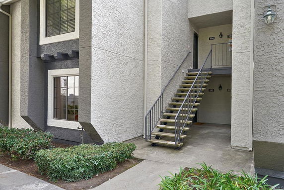 Front view of a building with an exterior staircase leading to upper floor entrances.