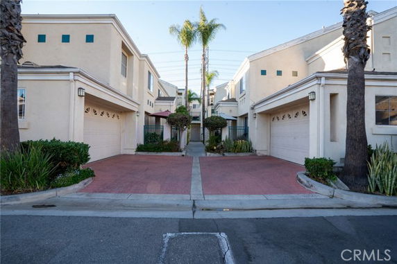 Front view of two-story houses with attached garages and a shared driveway.