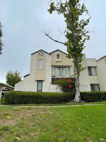 Front view of a multi-story house with a beige exterior and small windows.