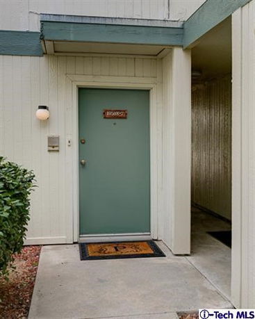 Front view of a building entrance with a teal door.