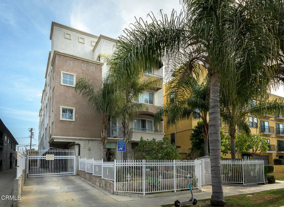 Front view of a multi-story residential building with gated entrance.