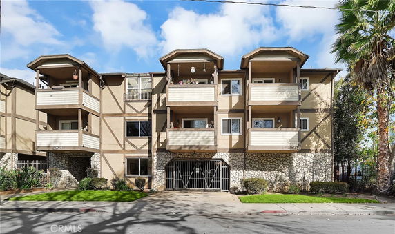 Front view of a three-story apartment building with balconies.