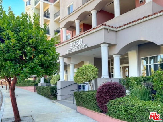 Front view of a multi-story residential building with columns at the entrance.