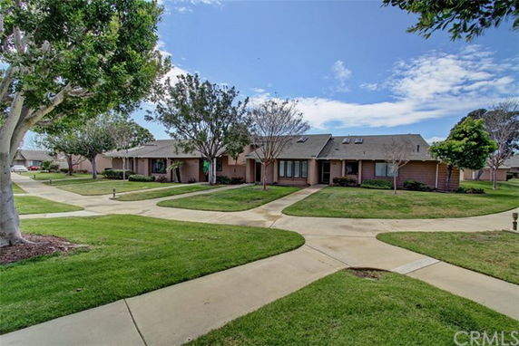 Front view of a single-story residential building with multiple units and a walkway.