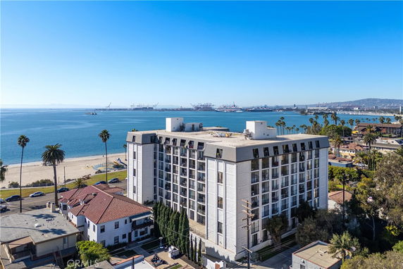 Multi-story apartment building near the beach with view of the ocean and distant ships.