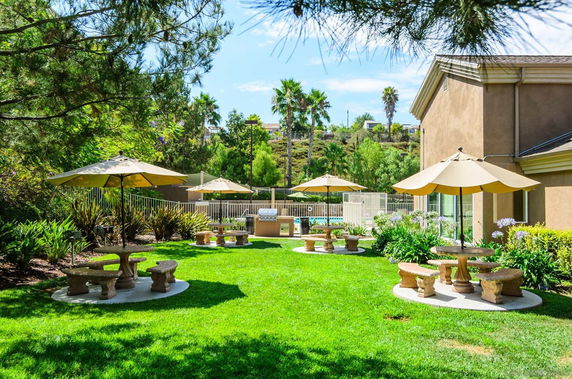 Outdoor area with umbrellas and seating near a building.