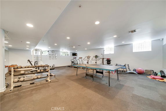 Indoor gym area with exercise equipment and a ping pong table.