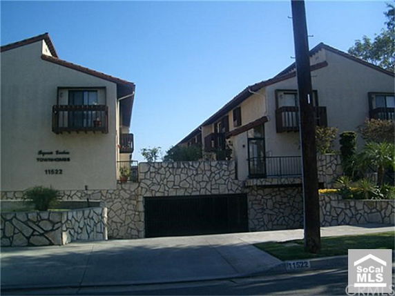Front view of a townhouse complex with stone accents and balconies.