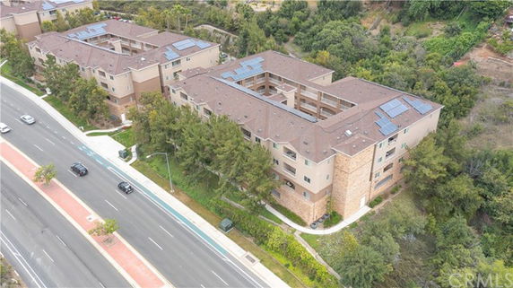 Aerial view of apartment buildings with solar panels on the rooftops.