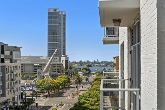 View from a building showing surrounding areas with a tall building and water body in the background.
