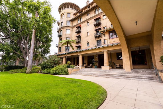 Front view of a multi-story building with a covered entrance and steps leading to the entry.