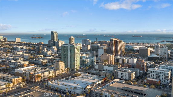 Panoramic view of a city skyline with buildings and the ocean in the background.
