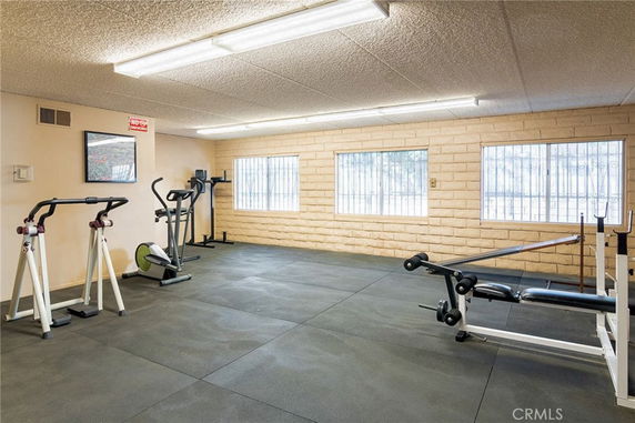 Indoor gym area with exercise equipment and windows.