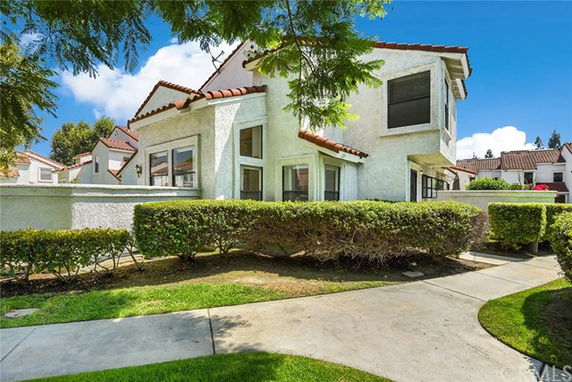 Front view of a two-story house with white walls and red-tiled roof.