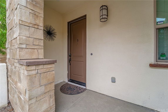 Front view of a house entrance with a brown door and brick detailing.