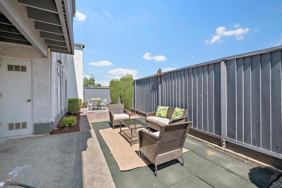 Rooftop terrace with outdoor seating area and high privacy fence.