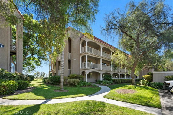 Front view of a multi-story apartment building with balconies.
