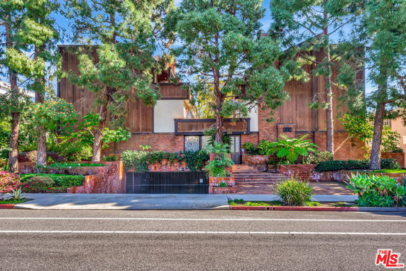 Front view of a two-story house with a mix of brick and wood facade.