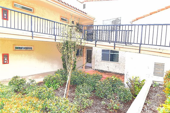 Front view of a multi-story building with a railing on the second floor.