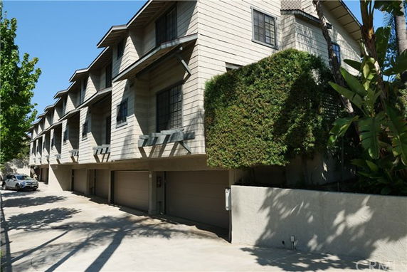 Front view of a multi-story building with garages and windows.