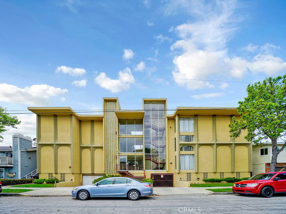 Front view of a modern, two-story building with large windows and a geometric facade.