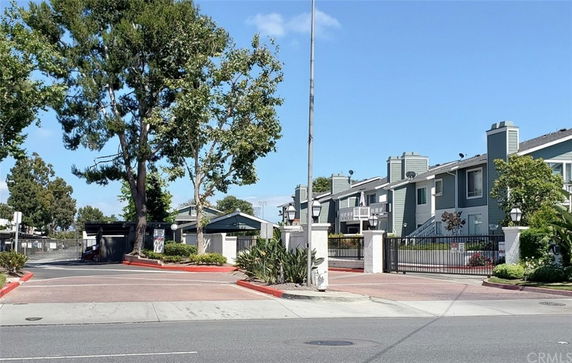 Front view of a multi-story residential complex with gated entrance.