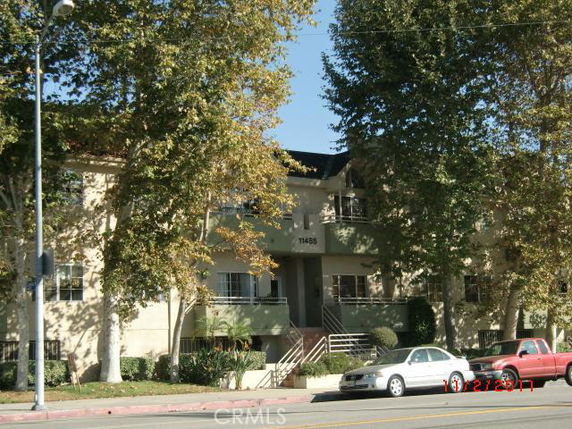 Front view of a two-story residential building with a central entrance and balcony.