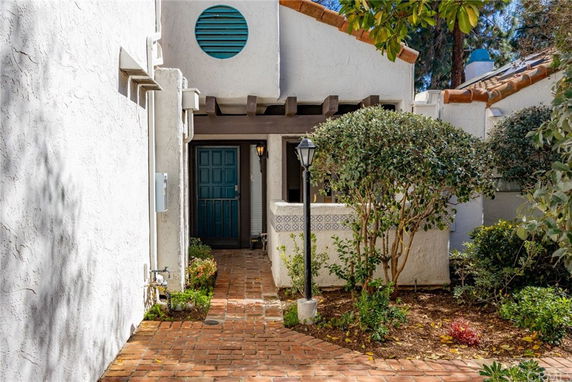 Front entrance of a house with a brick pathway and green door.