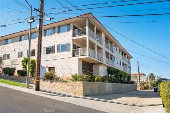 Front view of a multi-story residential building with balconies.